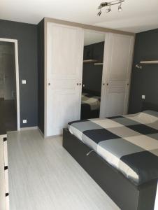 a bedroom with a bed with a black and white checkered floor at Villard au cœur de la vallée verte entre lac et montagne in Villard-sur-Boëge