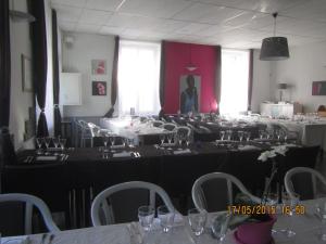 una stanza piena di tavoli e sedie con bicchieri da vino di Logis Hôtel Au Croissant a Buzançais