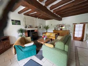 a living room with two couches and a table at Gîte Nature la Carillonnerie in Bossay-sur-Claise