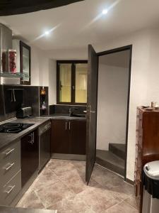 a kitchen with a door leading to a sink at Charmant duplex vue sur montagne in Le Broc +5 photos