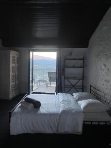 une chambre avec un grand lit et un balcon dans l'établissement Charmant duplex vue sur montagne, à Le Broc