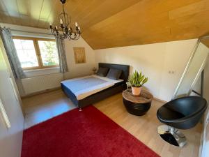 a bedroom with a bed and a chair and a red rug at Apartment Schlager Maria in Pirkach