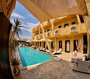 a hotel with a swimming pool in front of a building at Casa D'or Dahab in Dahab
