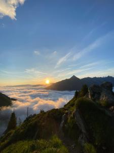 a view of the sun rising above the clouds on a mountain at ALPENCHALET LENGAU im Bergsteigerdorf Ginzling Dornauberg in Dornauberg +49 photos