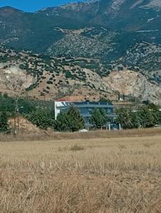 a building in the middle of a field with a mountain at Villa Athina BC in Serres