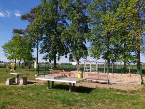 a park with a playground with benches and swings at Pensjonat Zielone Podlasie in Ruda