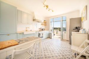 a kitchen with white cabinets and a counter top at Lovely vacation home in a picturesque countryside in Carvoeira