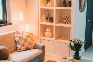 sala de estar con sofá y estanterías con jarrones en Charmante Maisonnette au Prado Carré d'Or by Maison Galante, en Marsella