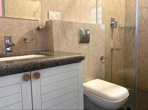 BardezCasa Cenica - 2bhk furnished apt, Arpora pool view的配有马桶、水槽和淋浴的浴室
