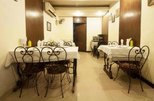 新德里的住宿－戈爾登利弗旅館，一间用餐室,内设桌椅