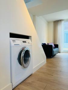 lavadora y secadora en la sala de estar en Zomerhuis - Gratis parkeren!, en Noordwijk aan Zee 13 fotos más