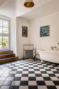 a bathroom with a black and white checkered floor and a tub at Gut Neuwerk in Kall