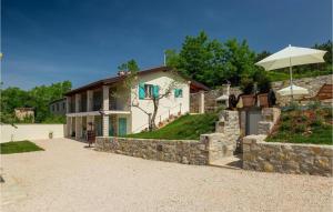 una casa con una pared de piedra y una sombrilla en Villa Cartolina by IstriaLux, en Bijele Zemlje