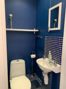 a blue bathroom with a toilet and a sink at 3 Bed Family House Free Parking in Southend-on-Sea +15 photos