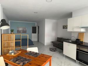 eine Küche und ein Wohnzimmer mit einem Tisch in einem Zimmer in der Unterkunft Kleines gemütliches Studio 1 in La Listada