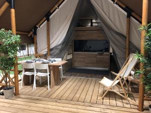 a tent with a table and chairs on a wooden deck at Gålö Havsbad - Resort and Holiday Cottages in Gålö