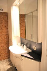 a bathroom with a white sink and a mirror at Cosy gezellig app met aparte gastenkamer op 30meter van strand privé garage in Koksijde +17 photos