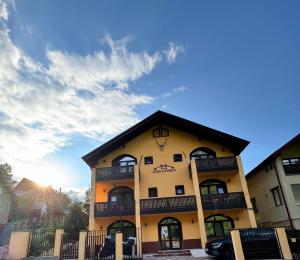 a large yellow building with a black roof at Casa Lupascu in Vatra Dornei