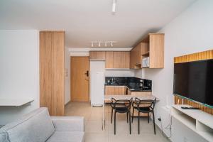 a kitchen with a couch and a table and chairs at Studio Central Independência 915 in Juiz de Fora