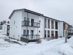 a large white building with snow in front of it at Kotimaailma - kodikas kolmio Espoossa in Espoo