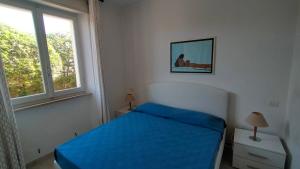 a bedroom with a blue bed and a window at P313 nr 102 trilocale sul mare con ombrellone in prima fila in Marcelli +8 photos