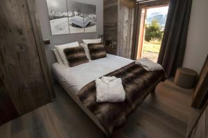 un letto grande in una stanza con una finestra di Chalet Boolly 5 étoiles - Bolquère a Bolquere Pyrenees 2000