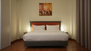 Ένα ή περισσότερα κρεβάτια σε δωμάτιο στο Manara Riva Suites