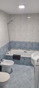 a bathroom with a tub and a toilet and a sink at Piso Boca da Ría in A Coruña +13 photos