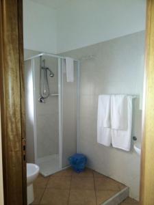 a bathroom with a shower and a toilet and towels at Locanda Scirocco in Castellammare del Golfo