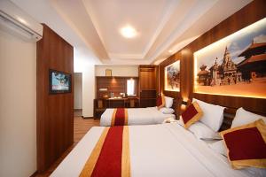 una camera d'albergo con due letti e una scrivania di Hotel Friends Home a Kathmandu
