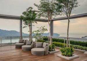 a living room with chairs and trees on a balcony at Iconic Regency Service Residences, managed by Iconic Hotel in Bayan Lepas