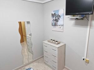 a room with a wall with a tv and a dresser at Appartement a louer a Torrevieja 100m de la plage in Torrevieja