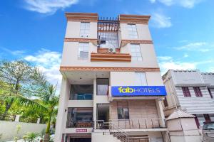 哥印拜陀FabHotel ESS Paradise - Nr Bus stand的上面有蓝色标志的高大的白色建筑