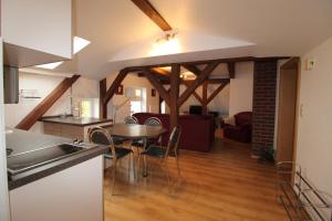 una cucina e un soggiorno con tavolo e sedie di Kapitänshaus FW 4 OG re a Wustrow