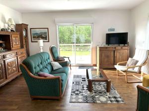 a living room with a couch and chairs and a tv at Maison à 500m de la mer et à 100m des commerces à TREGASTEL - Réf 20 in Trégastel