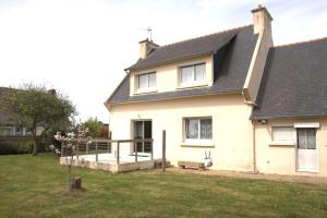 a white house with a porch and a yard at Maison à 500m de la mer et à 100m des commerces à TREGASTEL - Réf 20 in Trégastel