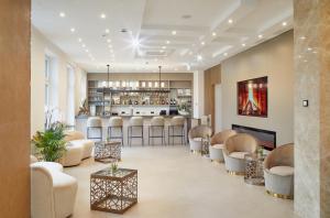 a lobby with chairs and a bar in the background at Hotel Kaiserhof in Bitterfeld
