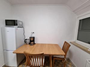 a small kitchen with a wooden table and a refrigerator at Bocholt Apartment Ferienwohnung in Bocholt