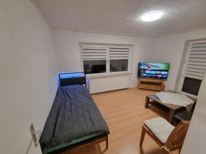 a living room with a bed and a flat screen tv at Bocholt Apartment Ferienwohnung in Bocholt