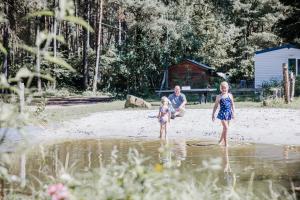 a man and two children standing in the water at Camping Siesta in Lille +2 photos