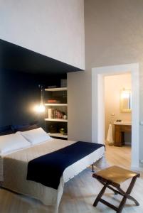 a bedroom with a large bed and a desk at Le Lumie in Modica