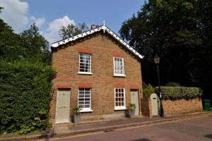 ein rotes Backsteingebäude mit weißen Fenstern und Türen in der Unterkunft Charming Cottage with Roof Terrace in Twickenham