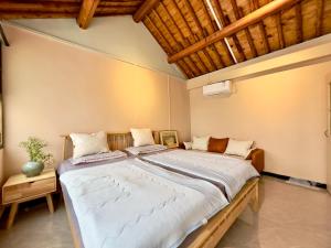 a large bed in a room with a wooden ceiling at Black Stone Great Wall Lodge in Simataicun