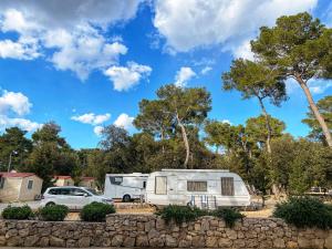 a campsite with a caravan and a car and trees at Camping Park Soline Pitches in Biograd na Moru