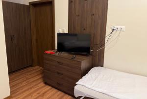 a bedroom with a tv on a dresser with a bed at Willa Ogrodnika in Błażowa