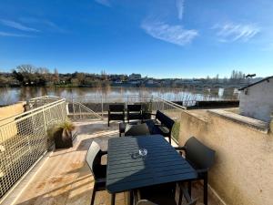una terrazza con tavolo, sedie e vista sul fiume di T2 climatisé face Loire et château le 4-4 a Amboise