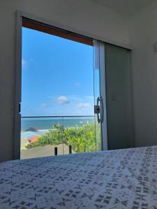 a bedroom with a bed and a view of the ocean at Vista Mar Emboaca in Estrela