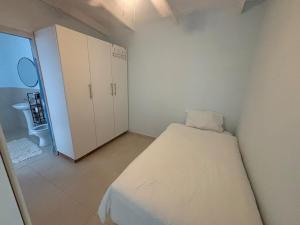 a small bedroom with a bed and a cabinet at Ballito Holiday Home in Ballito +5 photos
