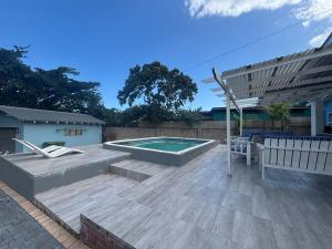 a backyard with a swimming pool and an umbrella at Ballito Holiday Home in Ballito