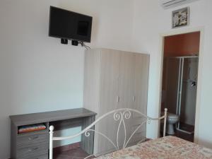 a bedroom with a bed with a tv on the wall at Segesta Antichi Sapori in Calatafimi
